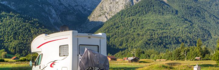 Ein weißes Wohnmobil parkt auf einem Campingplatz.