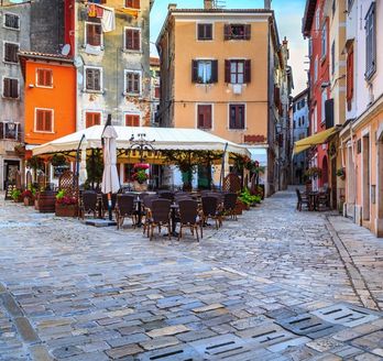 Ein Café in Rovinj mit Tischen und Stühlen.