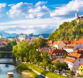 Eine Stadtansicht von Ljubljana, Slowenien, mit einem Fluss und bunten Gebäuden.