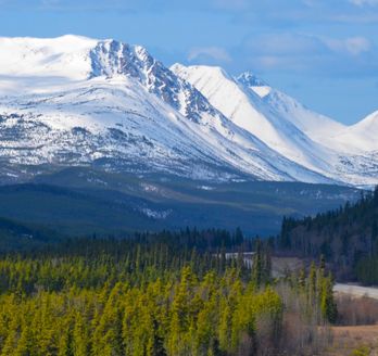 Straße in Richtung schneebedeckte Berge in Kanada