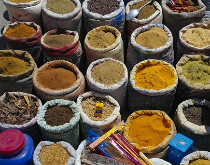 Bunte Gewürzsäcke voller duftender Kräuter, Samen und Pulver verwandeln den Markt in ein aromatisches Farbenmeer.