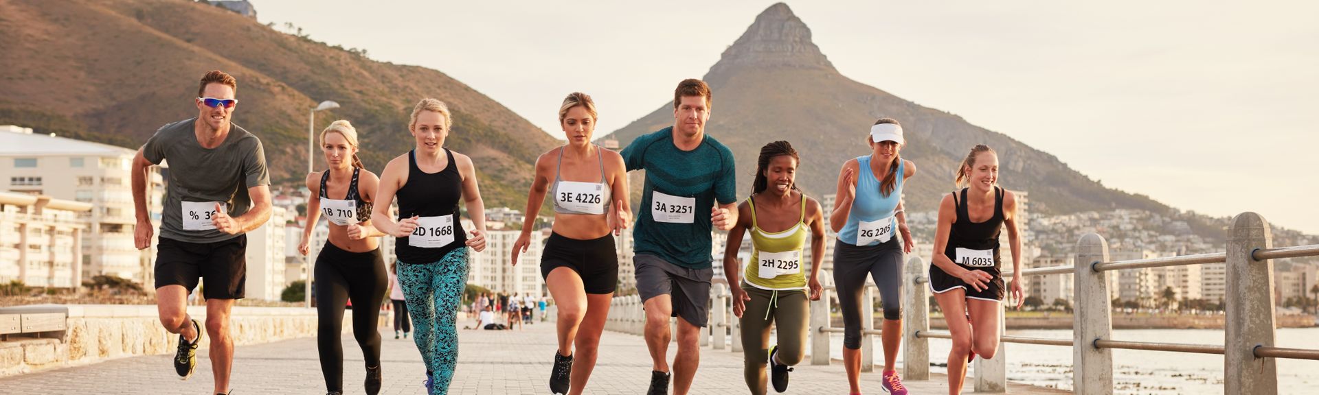 Eine Gruppe Marathonläufer und Läuferinnen läuft vor dem Tafelberg in Kapstadt