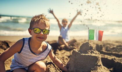 Kind baut eine Sandburg am Strand