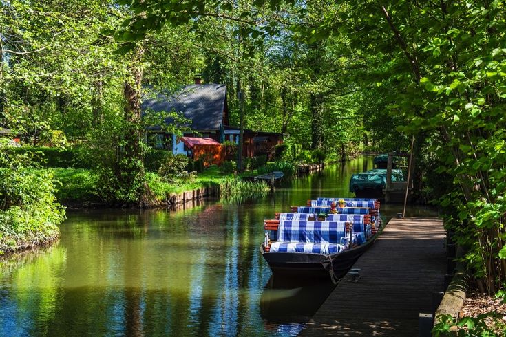 Ein traditioneller Spreewaldkahn gleitet durch die Kanäle des Spreewaldes, umgeben von üppigem Grün und dichten Wäldern.