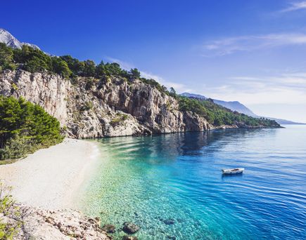 Ein felsiger Strand mit einem Felsen, der ins Meer ragt.