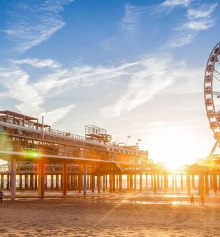 Ein Riesenrad am Strand bei Sonnenuntergang.