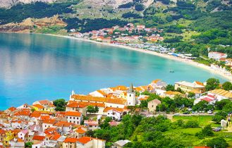 Eine Luftaufnahme einer Küstenstadt mit einer Insel und dem Meer.