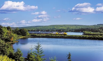 Schnellzug der kanadischen VIA Rail  im Vordergrund Wasser, Zug am Horizont