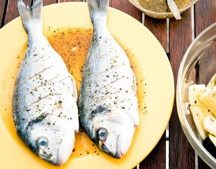Zwei Fische auf einem Teller mit Zitrone.