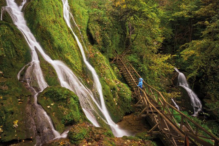 Ein Wasserfall, der in mehrere Stufen über Felsen fließt.