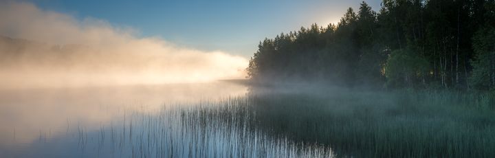 Mystischer Sonnenaufgang über der finnischen Seenplatte