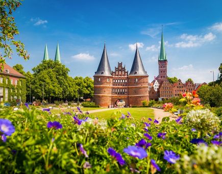 Blick auf das Holstentor in Lübeck bei strahlend blauem Himmel.