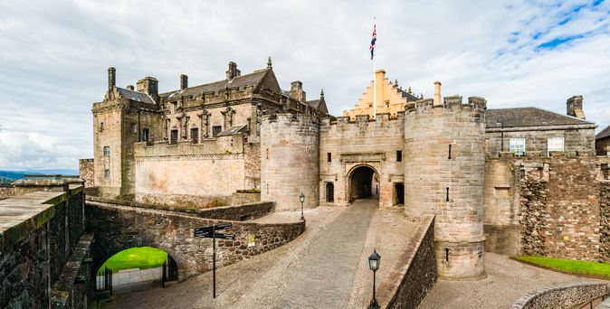 Das beeindruckende Stirling Castle thront majestätisch auf einem Felsen in Schottland, umgeben von grünen Feldern und einem weiten Himmel, und ist ein Wahrzeichen der schottischen Geschichte.
