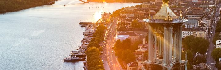 Die Skyline von Stockholm bei Sonnenuntergang, mit einem See und Gebäuden.