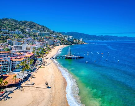 Blick über einen Strandabschnitt in Mexico. Türkiesblaues Meer, blauer Himmel.