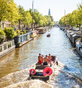 Eine Person in einem roten Kajak auf einem Kanal in Amsterdam.