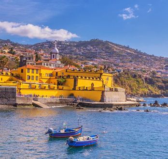 Eine Hafenstadt mit bunten Gebäuden und einem Schiff.