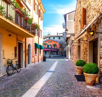 Eine enge Gasse mit Gebäuden und Pflanzen.
