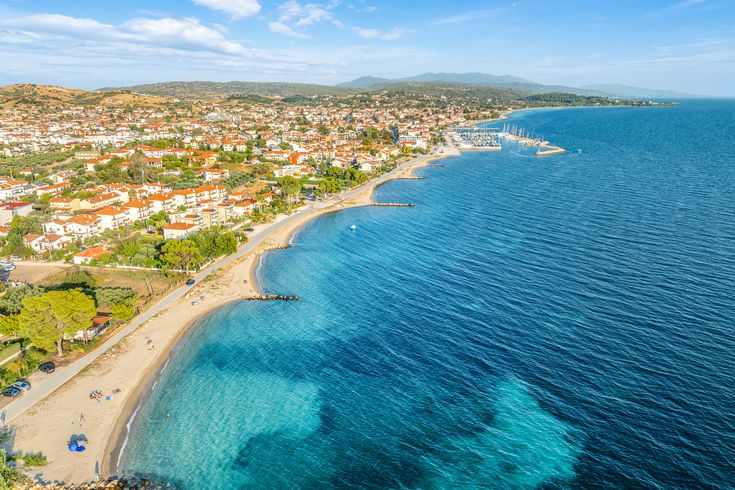 Blick auf Nikiti aus der Vogelperspektive. Strand, grüne Vegetation und einige Häuser.