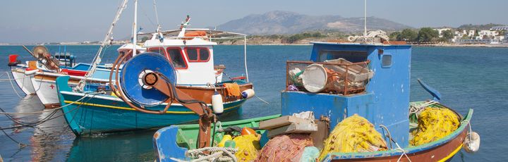 Fischerboote in der Bucht von Mastichari, blauer Himmel.