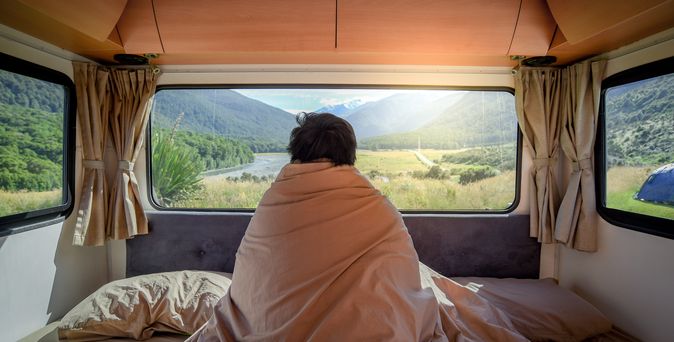 Mann im Wohnmobil unter einer Decke