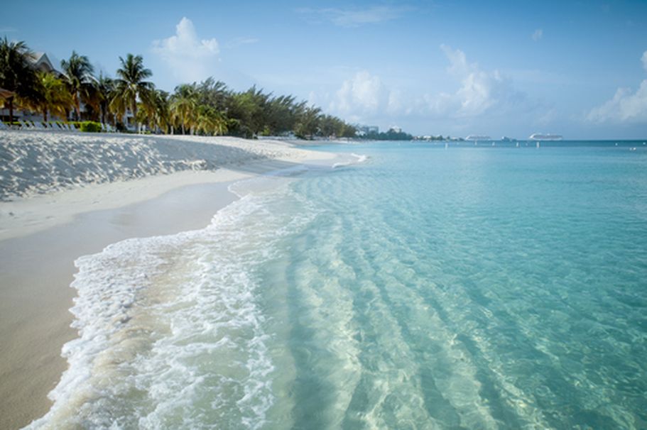 Ein Sandstrand mit türkisfarbenem Wasser.