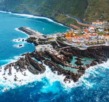 Blick auf Porto Moniz aus der Vogelperspektive. Felsige Küste umgeben vom tobenden Meer.