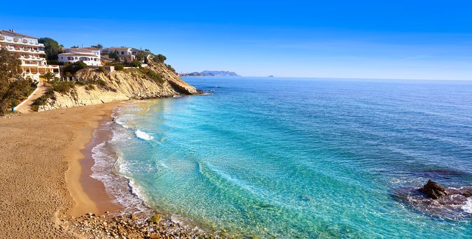Blick über Strand und das Meer in eine Bucht an der Costa Blanca