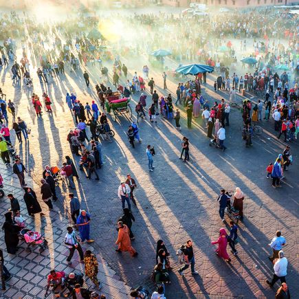 Viele Menschen stehen auf Marktplatz Djemaa el Fna
