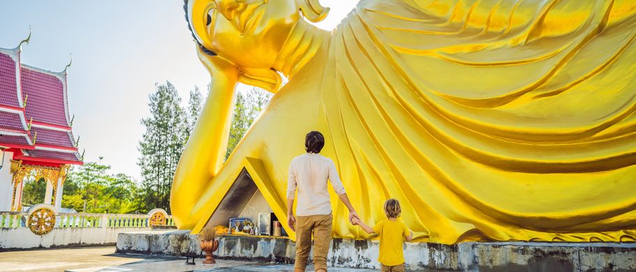 Familie vor Buddhastatue, Thailand