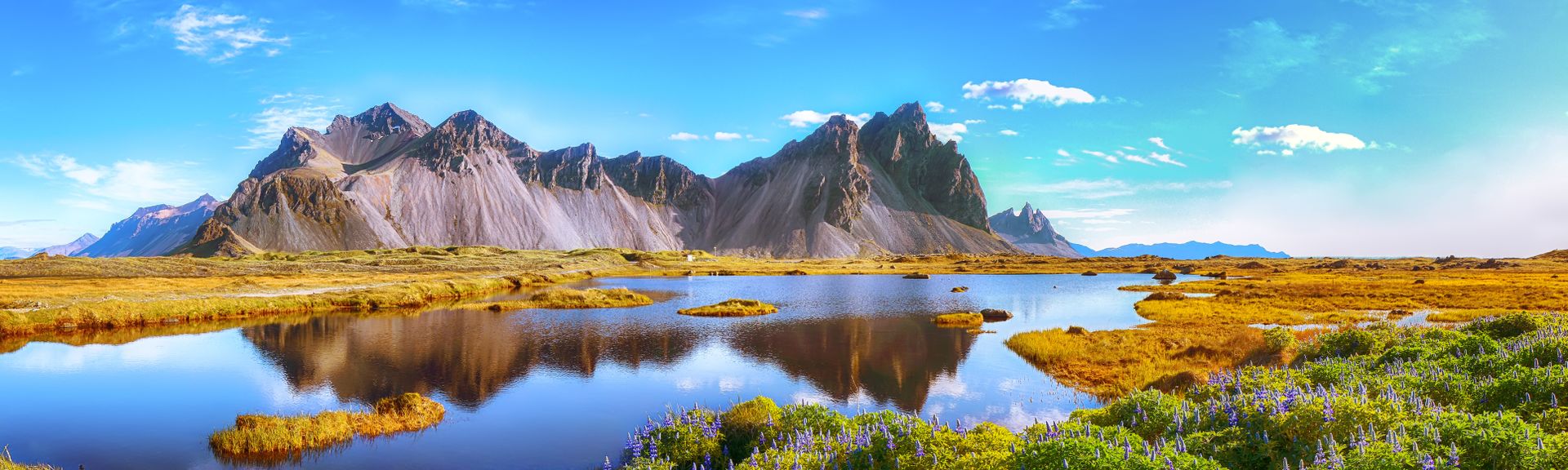 Island mit Bergen im Hintergrund und Wasser im Vordergrund