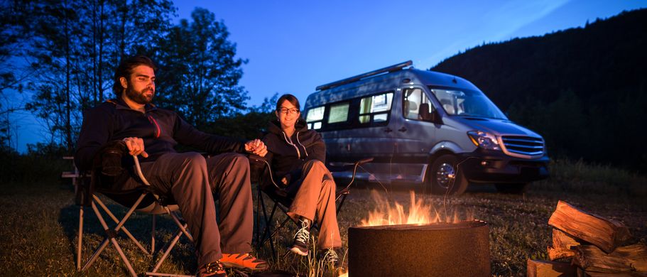 Info Camper Handbuch Wohnmobil Urlaub Lagerfeuer vor Wohnmobil
