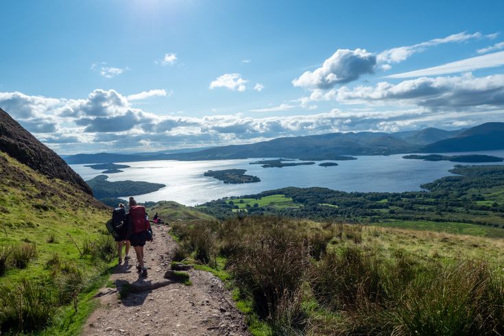 Blick auf das weitläufige Loch Lomond. Wanderer sind ebenfalls zu sehen.