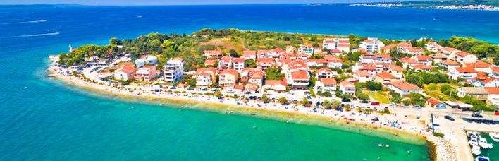 Eine Luftaufnahme einer Küstenstadt mit einer Insel und dem Meer.