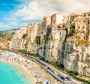 Ein Strand mit türkisfarbenem Wasser und einem felsigen Ufer.