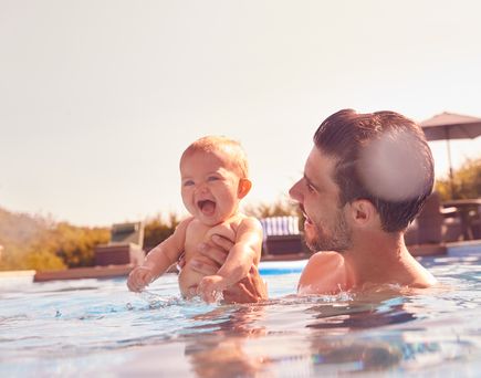 Vater mit baby im Pool