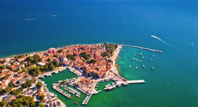 Eine Luftaufnahme der Stadt Novigrad in Istrien, Kroatien, mit Gebäuden, die ins Meer ragen.