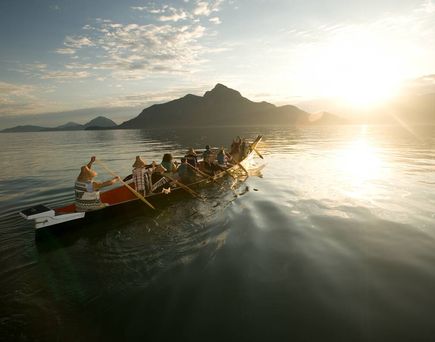 Ruderboot auf auf einem See mit Bergen im Hintergrund 