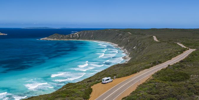 Wohnmobil steht an Küstenstraße mit blauem Meer und blauem Himmel in Australien 