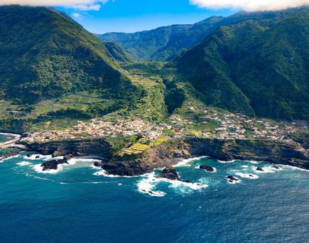 Eine Luftaufnahme einer Küstenstadt mit Bergen, die ins Meer ragen.