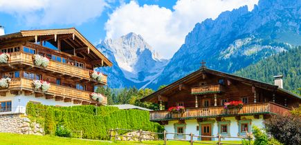Zwei Häuser mit Alpen im Hintergrund