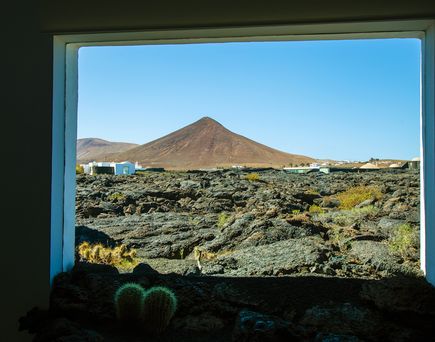Blick aus Fenster auf felsige Landschaft im Hintergrund ein Berg in Lanzarote