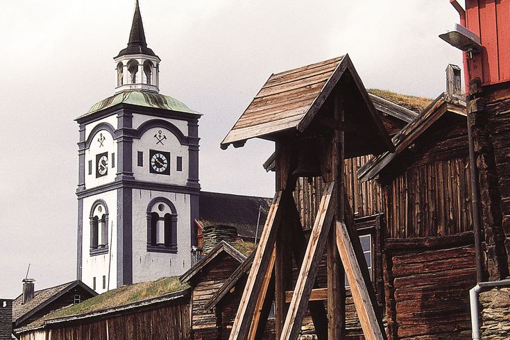 Eine alte, traditionelle Stabkirche in Norwegen, umgeben von grüner Vegetation.