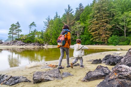 Mutter mit Kind läuft am Wasser auf Vancouver Island