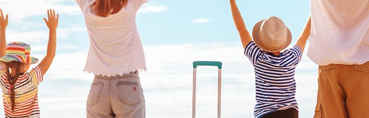 Familie am Strand mit Koffern 