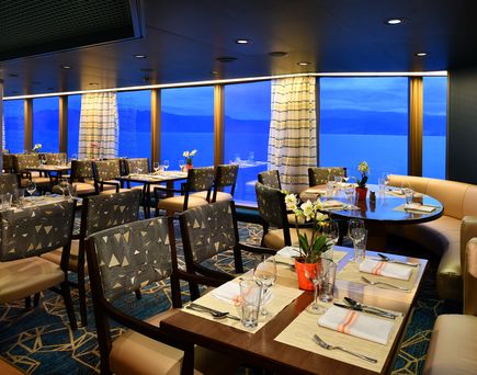 Blick auf das Restaurant mit gedeckten, brauen Tischen und beigen Stühlen