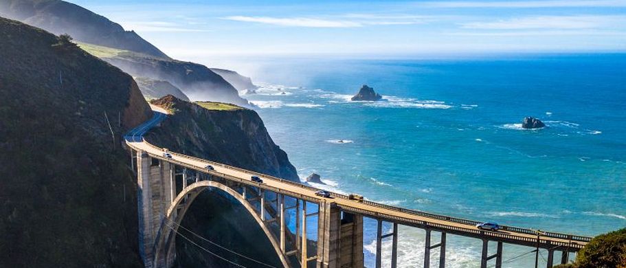 Die Bixby Creek Bridge am Pacific Coast Highway in Kalifornien, eine imposante Betonbrücke, die sich über eine tiefe Schlucht mit Blick auf den Pazifischen Ozean erstreckt.