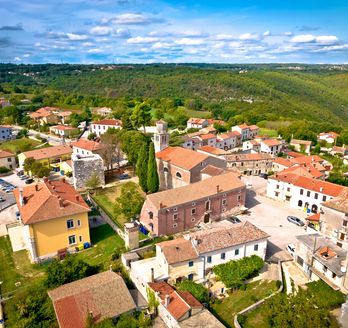 Eine Luftaufnahme einer Stadt mit roten Dächern und Blick auf das Meer.