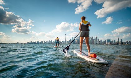 Stand Up Paddle Fahrer auf dem Lake Ontario vor der Skyline von Toronto mit dem CN Tower