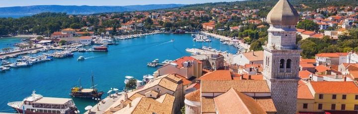 Die Altstadt von Krk, Kroatien, mit roten Dächern und einem Kirchturm.